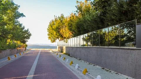 A sunlit road surrounded by trees, symbolizing the journey toward goals, su.. Stock Photos