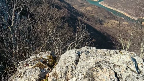 Sunlit rock formation with sparse greenery. Balkan, Eastern Europe, POV Video stock 331815172