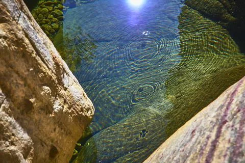 Sunlit Rock Formations and Clear Water Pool with Rippling Patterns Foto stock