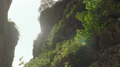 Sunlit Rocky Cliffs with Greenery Stock Footage 282937434