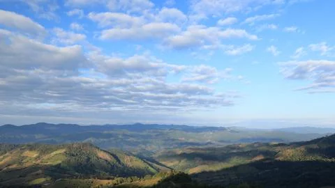 Sunlit Rolling Mountains Stretch Under Expansive Blue Sky Panoramic View Stock Photos