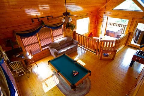 Sunlit Rustic Cabin Interior with Pool Table and Loft View, Gatlinburg Tennessee 스톡 사진