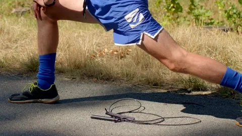 Sunlit scene of athlete practicing flexibility with jump rope Stock Footage 320955571