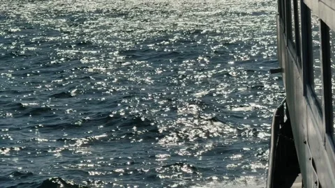 Sunlit sea surface sparkles viewed from the side of a moving ferry Vidéo 321391625