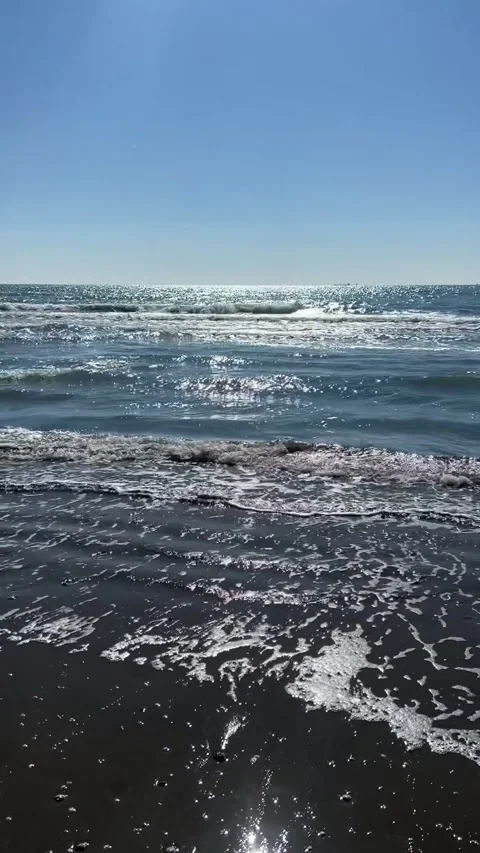 Sunlit Sea Waves on a Sandy Beach Stock Footage 310939160