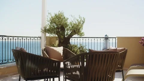 Sunlit seaside terrace with olive tree and lighthouse reveal Stock Footage 327013726