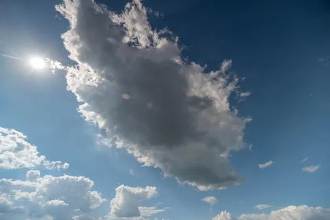 Sunlit sky with dramatic cumulus cloud and bright sun 写真素材