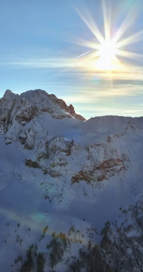Sunlit snowy mountain peak with rainbow light effect during golden hour, ae.. Stock Footage 339213311