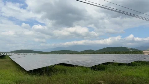 Sunlit solar structures extend toward distant highlands, reflecting pale sky Stock Footage 324625035