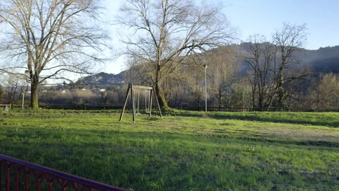 Sunlit Solitude: A Swing Set on a Verdant Spring Meadow Stock Footage 265005454