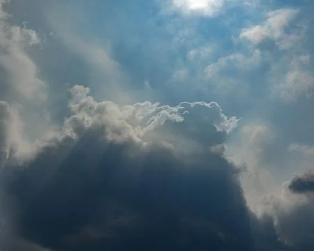 Sunlit Storm Clouds: Dramatic Rays in Clearing Blue Sky Stock Photos