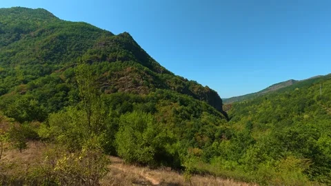 Sunlit trail winds through green hills. Temska River Canyon, Serbia 動画素材 345897613