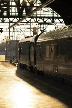 Sunlit train at station platform Stock Photos