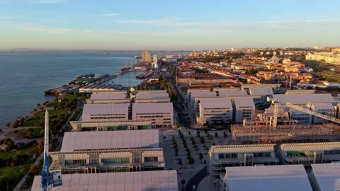 Sunlit urban coastal complex with sleek rooftops and open spaces; Braco de Prata Video stock 346069885