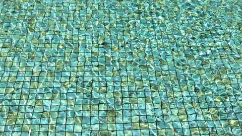 Sunlit Water Ripples over Blue Mosaic Tile Pool Bottom 스톡 동영상 337696936