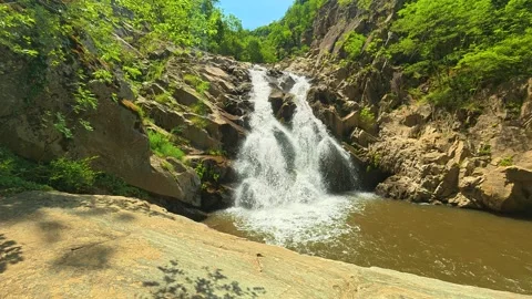 Sunlit waterfall cascades over mossy rocks. Vucjanka Canyon, Serbia 库存影片 341127712