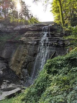 Sunlit waterfall cascading down a cliff in Cuyahoga Valley National Park 写真素材