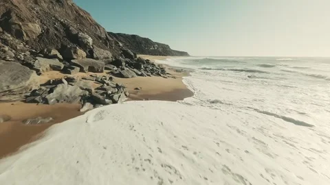 Sunlit waves crash softly on golden sand Video stock 341825430