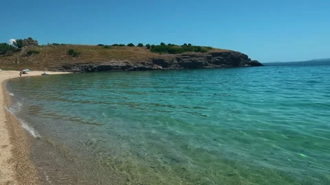 Sunlit waves lap gentle sand. Trani Ammouda, Greece Stock Footage 339613134