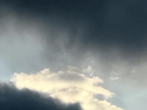 Sunlit White Cloud Beneath Dark Storm Layer Stock Photos