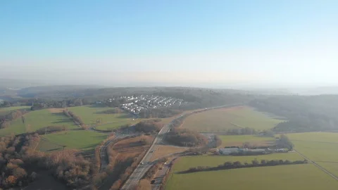 Sunny backwards Drone flight over fields, cars, roads Stock Footage 103071232