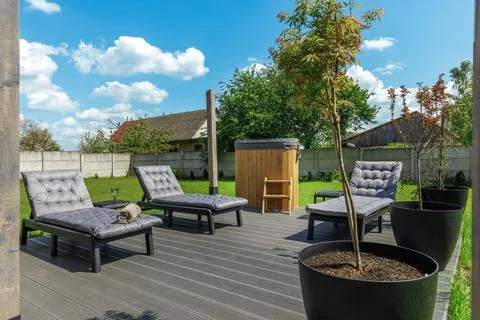 Sunny Backyard Spa Deck with Sun Loungers and Hot Tub Stock Photos