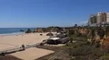 Sunny beach cliffs zoom and city buildings with blue sky in Portimao Portugal 4k or 4k+ Resolution