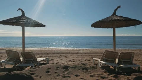 Sunny beach loop with parasol and chairs Stock Footage 145382065
