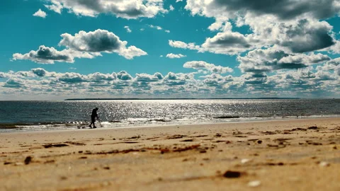 Sunny Beach Scenes with Ocean Waves, Silhouette of a man with a metal detector Stock Footage 293056875