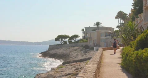 Sunny coastal path in Cap d Ail with Mediterranean sea views, rocky shoreline Stock Footage 342813185