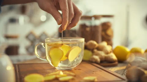 As sunny day brightens warm kitchen mans hand expertly stirs hot ginger tea Stock Footage 331315732