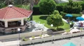 Sunny day in hotel area with resting people. Poolside review from the top HD Footage