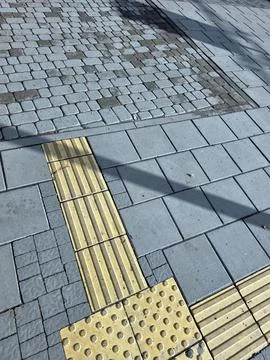 A Sunny Day Reveals the Unique Patterns of a Cobblestone Sidewalk Stock Photos