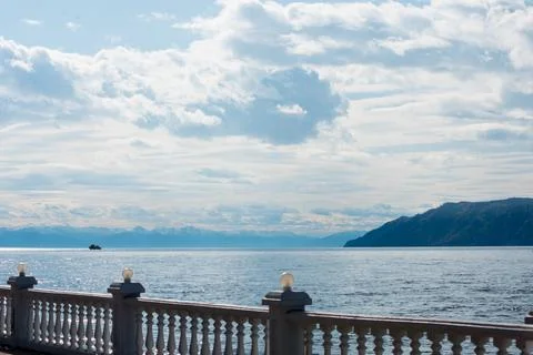 Sunny day on the shore of Lake Baikal. Water and blue sky with clouds. Beauti Stock Photos