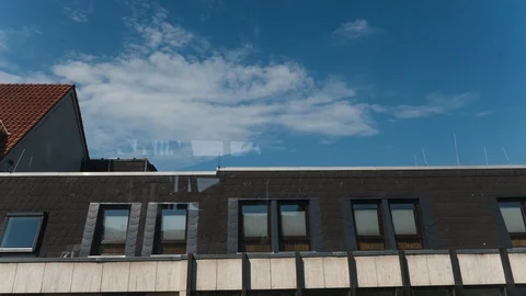 Sunny Daytime Clouds in Time-Lapse above Building Rooftop Stock Footage 121224774