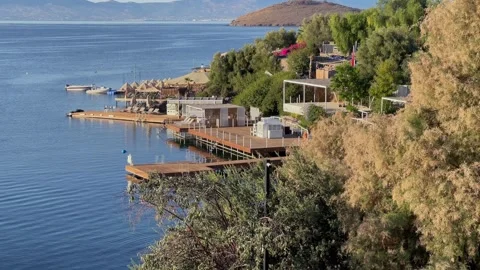 A sunny elevated view of a coastal resort featuring wooden piers, sun loungers,  Stock Footage 343993191