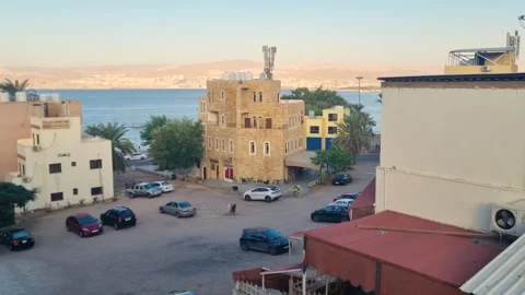 Sunny evening city view in central Aqaba, Jordan, showing a calm urban parking Stock Footage 337089677