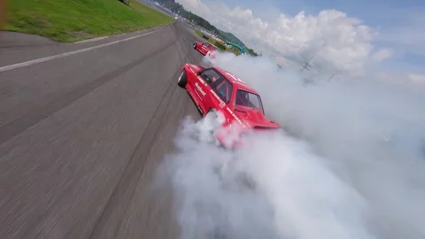 Sunny FPV Drone Chase of Two Red Cars in Smoky Tandem Drift Battle Stock Footage 336198733