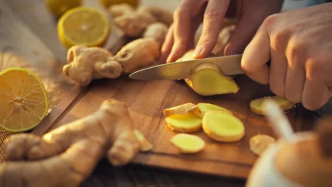 In sunny kitchen mans hands skillfully chop fresh ginger rhizome releasing i Stock Footage 331355923