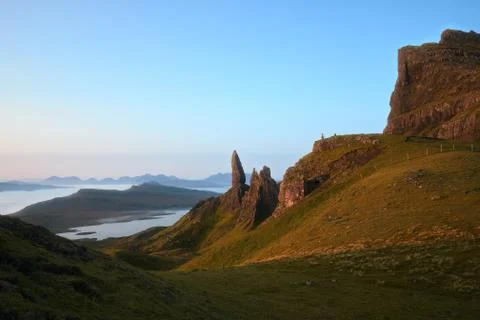 Sunny landscape with the high sharp cliffs towering over the lake and the sea in Stock Photos