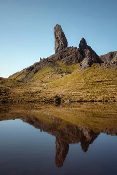 Sunny landscape with the high sharp cliffs towering over the lake in the morning Stock Photos
