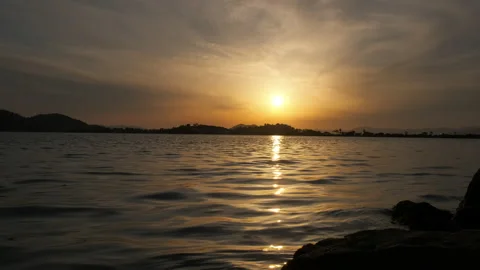 Sunny path to the sea, against the backdrop of the sun setting over the islands. Stock Footage 233121555