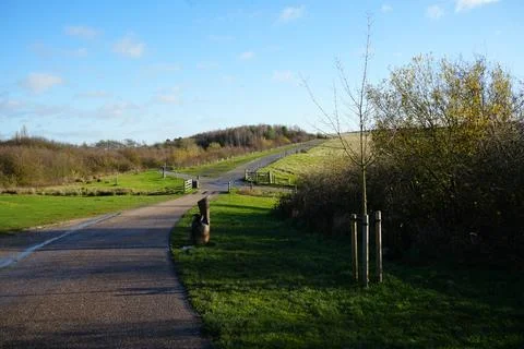 Sunny Paved Path Through Green Fields At Gedling Country Park, Nottingham, Stock Photos