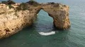 Sunny sand stone cliffs arch rock at Algarve coastline Portugal 4k or 4k+ Resolution