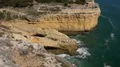 Sunny sand stone cliffs landscape tilt up at Algarve coastline Portugal 4k or 4k+ Resolution