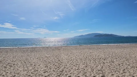Sunny Sandy Beach with Ocean Waves and Mountains on Horizon Vídeos de archivo 345620450
