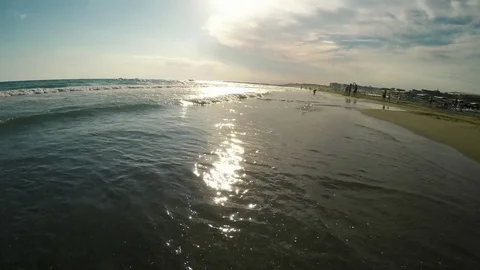 Sunny sandy sea ocean beach and surf waves in the sun rays. Summer holiday Stock Footage