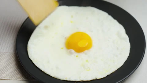 Sunny side egg in black pan on round plate with bright yolk. Video stock 348240909