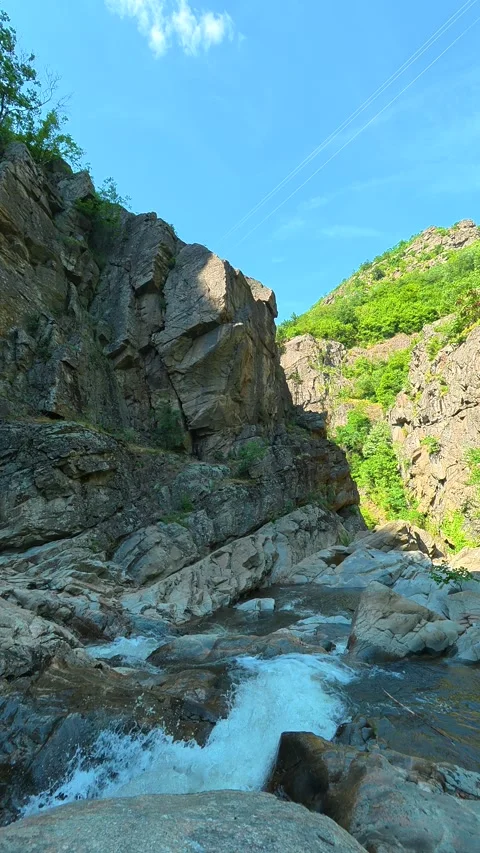 Sunny sky frames steep, green-covered cliffs. Vucjanka Canyon, Serbia. Vertical Stock Footage 341131408