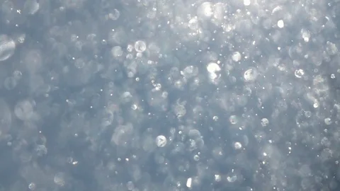 Sunny snowfall in shallow focus with sparkling snowflakes on blue sky Stock Footage 87871865